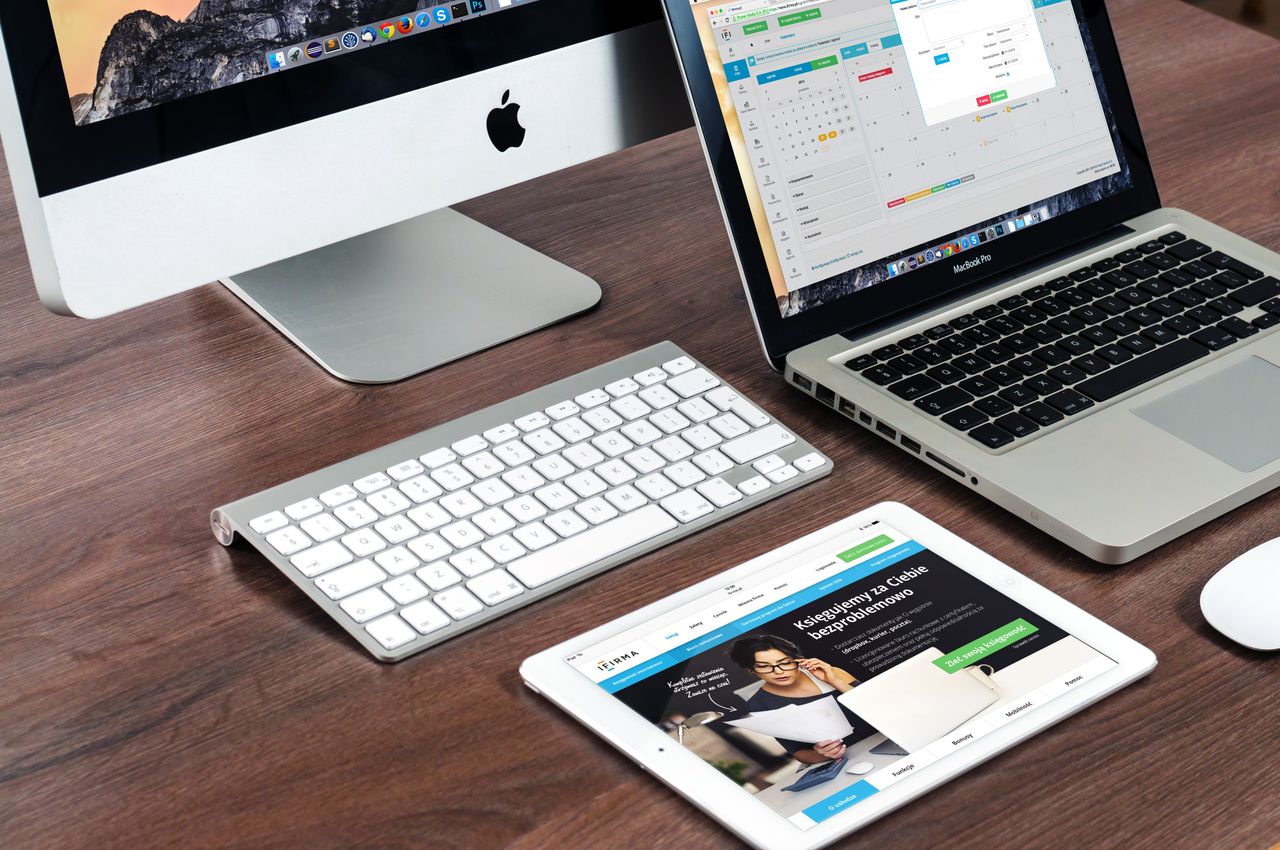 heros-img Un bureau de travail élégant avec des appareils Apple : iMac, MacBook et iPad.
